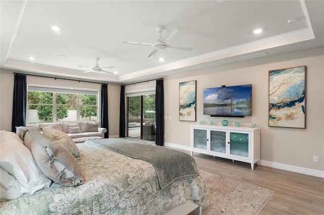 bedroom featuring baseboards, access to exterior, ornamental molding, light wood-style floors, and a tray ceiling