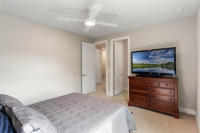 bedroom featuring baseboards, a ceiling fan, and light colored carpet