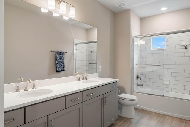 full bath featuring visible vents, wood finished floors, double vanity, and a sink