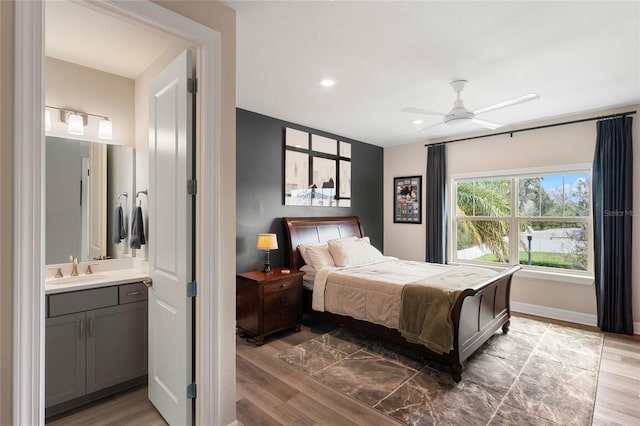 bedroom featuring baseboards, a sink, connected bathroom, recessed lighting, and wood finished floors