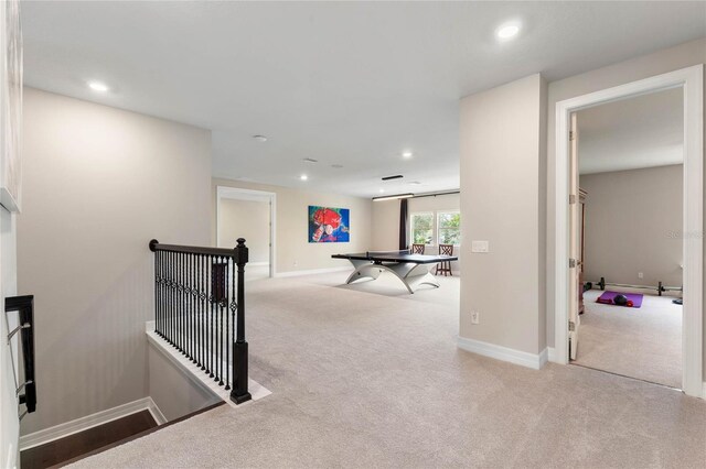 hallway featuring recessed lighting, an upstairs landing, and light carpet