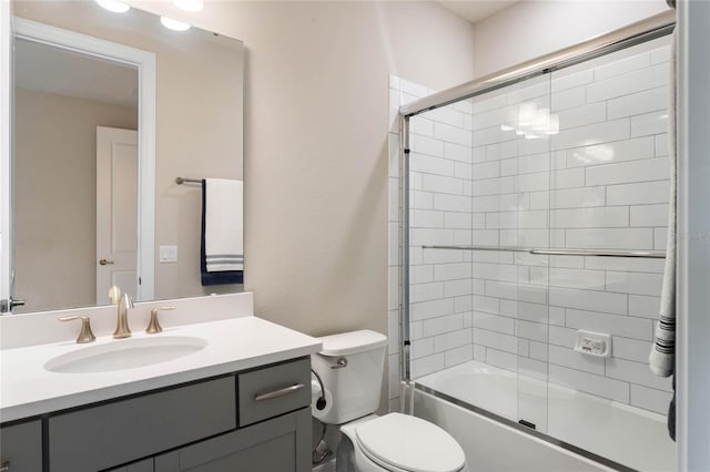 full bath featuring toilet, vanity, and bath / shower combo with glass door