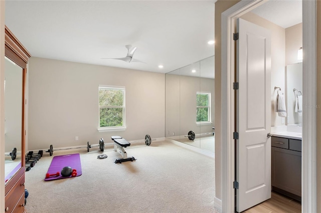 exercise area featuring recessed lighting, a ceiling fan, light colored carpet, and baseboards