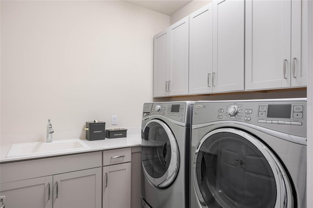 laundry area with cabinet space, a sink, and washing machine and dryer