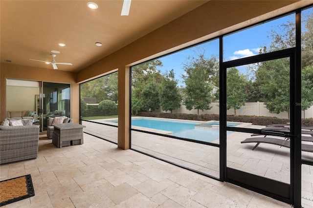 unfurnished sunroom with ceiling fan