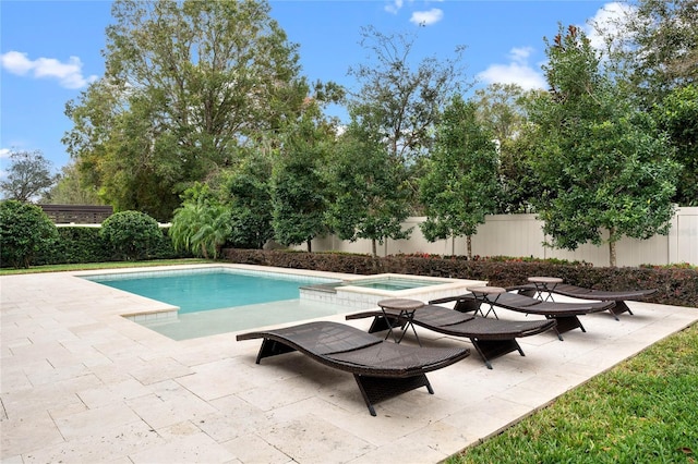 view of pool featuring a fenced backyard, a pool with connected hot tub, and a patio area