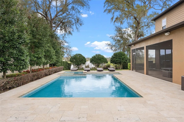 view of pool with a pool with connected hot tub, a sunroom, and a patio