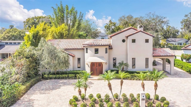 mediterranean / spanish home with driveway, a tiled roof, and stucco siding