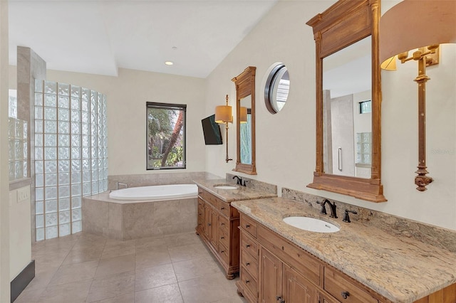 full bath with two vanities, a garden tub, a sink, and tile patterned floors