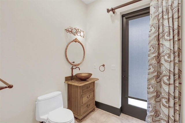 full bath featuring tile patterned flooring, baseboards, vanity, and toilet