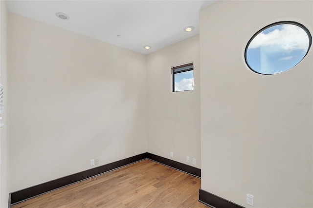 spare room with recessed lighting, baseboards, and light wood finished floors