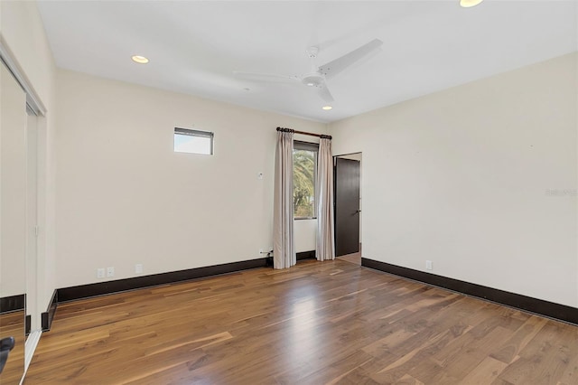 empty room featuring a ceiling fan, baseboards, wood finished floors, and recessed lighting