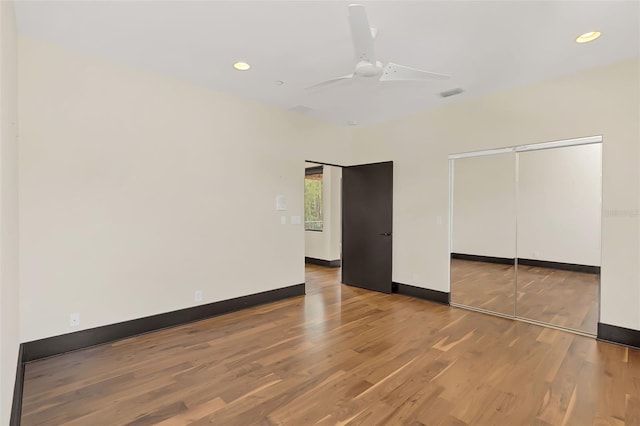 unfurnished bedroom with recessed lighting, a closet, visible vents, wood finished floors, and baseboards