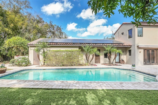 pool with a patio, a lawn, and french doors