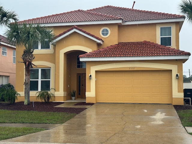 mediterranean / spanish house featuring a garage, driveway, a tile roof, and stucco siding