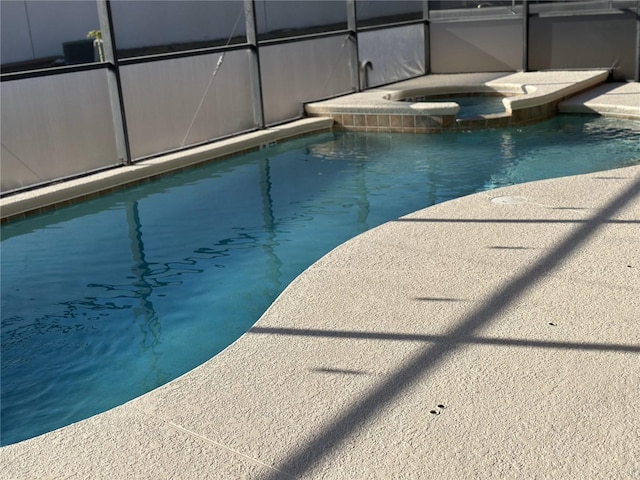 view of pool with a pool with connected hot tub