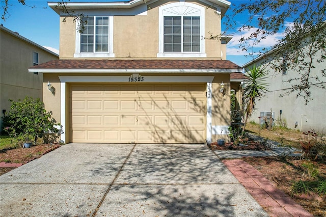 view of front of home featuring stucco siding, a garage, driveway, and a shingled roof