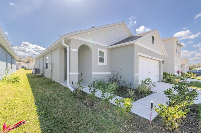 view of property exterior with a yard, central air condition unit, and a garage