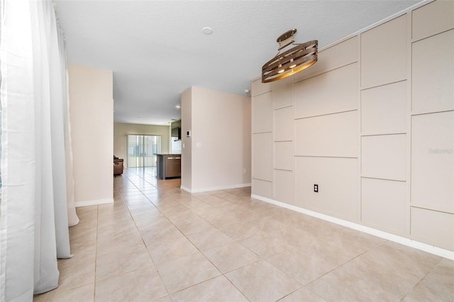 empty room with light tile patterned flooring and a textured ceiling