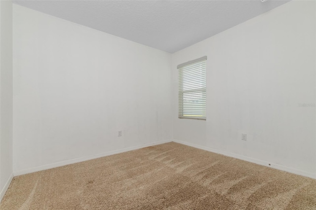 carpeted spare room with a textured ceiling