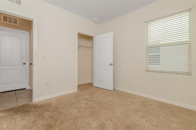 unfurnished bedroom with light carpet and a closet