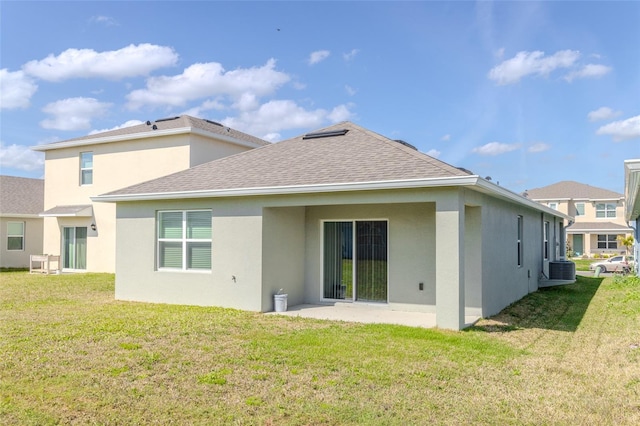 rear view of house with cooling unit, a yard, and a patio