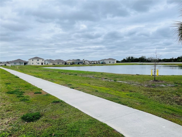 surrounding community featuring a water view and a yard