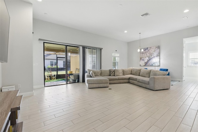 living area with light wood finished floors, plenty of natural light, visible vents, and baseboards