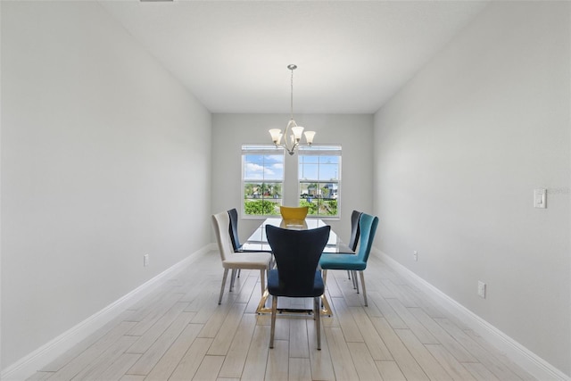 dining space featuring a chandelier, light wood finished floors, and baseboards