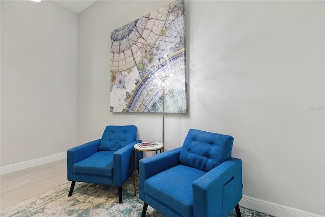 living area featuring baseboards and wood finished floors