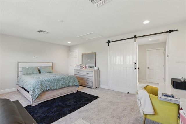 bedroom featuring light carpet, a barn door, visible vents, and attic access