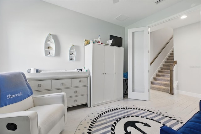 living area featuring light wood-style flooring, stairway, and baseboards