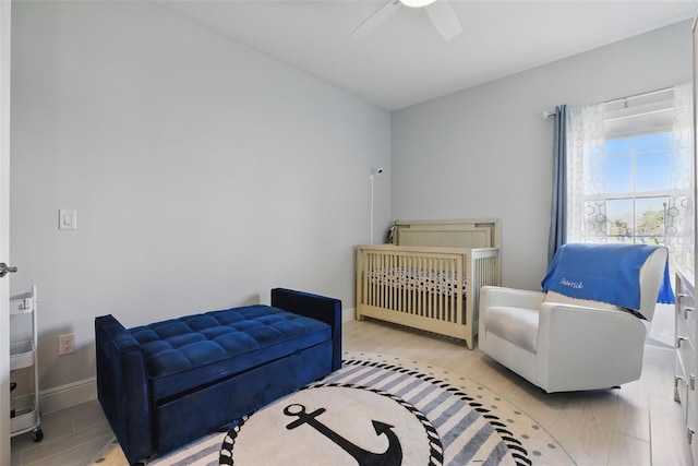 bedroom featuring ceiling fan, light wood-style flooring, and baseboards