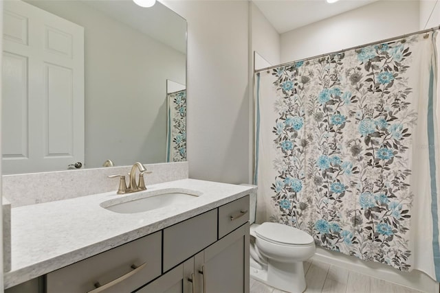 bathroom featuring a shower with curtain, vanity, and toilet