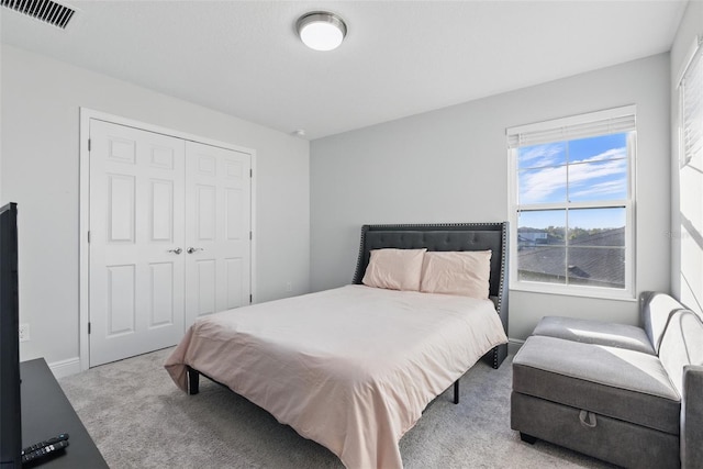 bedroom featuring a closet, visible vents, baseboards, and carpet flooring