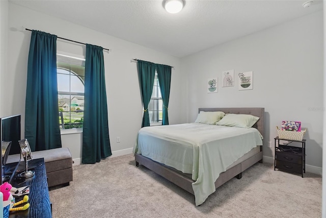 carpeted bedroom featuring baseboards and a textured ceiling