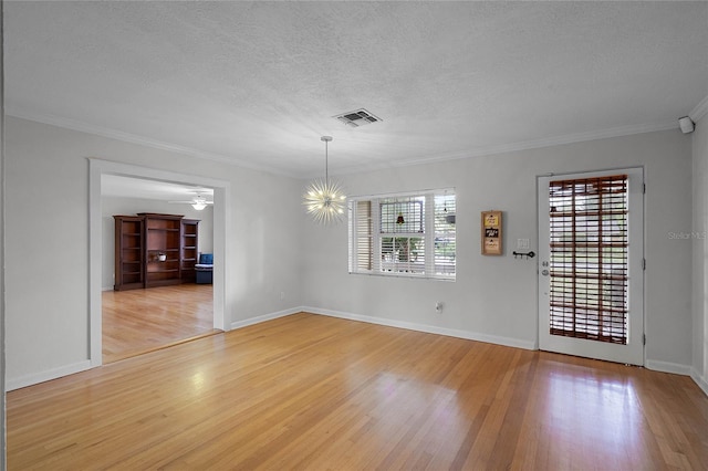 unfurnished dining area featuring ceiling fan with notable chandelier, wood-type flooring, ornamental molding, and a textured ceiling