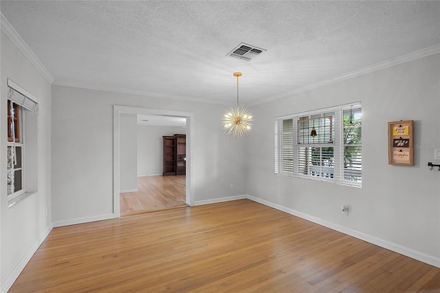 spare room featuring ornamental molding, an inviting chandelier, and light hardwood / wood-style flooring