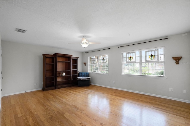 interior space with ceiling fan, a textured ceiling, and light hardwood / wood-style floors