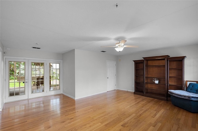 unfurnished room with ceiling fan, light wood-type flooring, and french doors