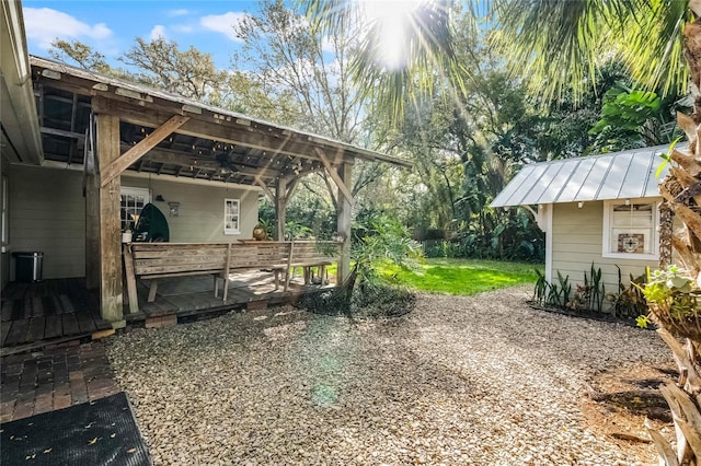 view of yard with ceiling fan and a deck