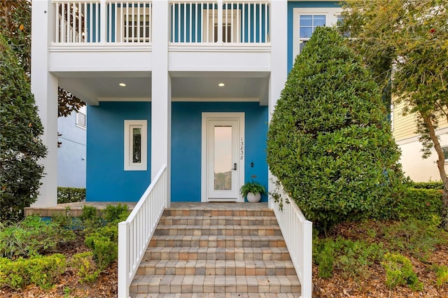 doorway to property with a balcony and stucco siding