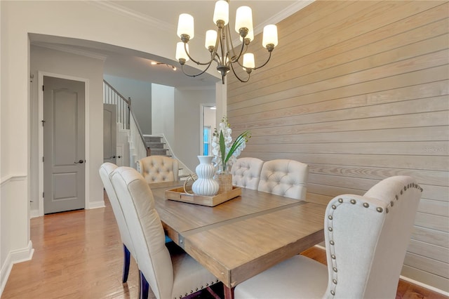 dining space featuring stairs, ornamental molding, and wood finished floors