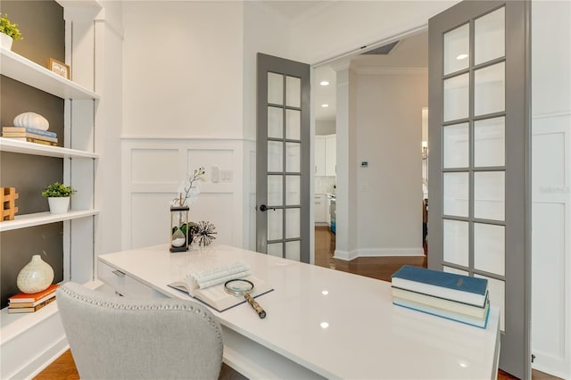 office area featuring dark wood finished floors, visible vents, a decorative wall, ornamental molding, and wainscoting