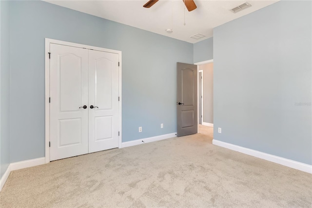 unfurnished bedroom featuring carpet flooring, a ceiling fan, visible vents, baseboards, and a closet