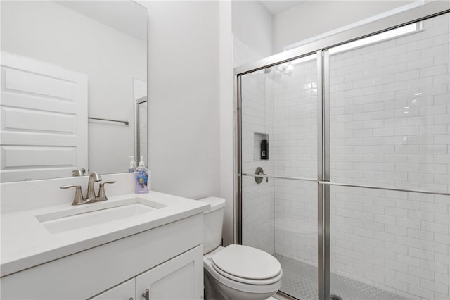 bathroom featuring vanity, walk in shower, and toilet