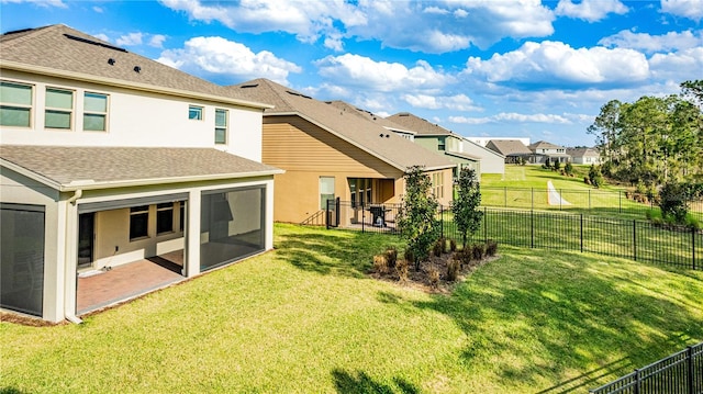 back of house with a patio, a sunroom, and a lawn