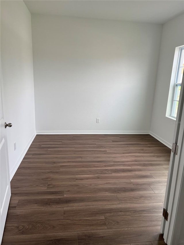 unfurnished room with dark wood-type flooring