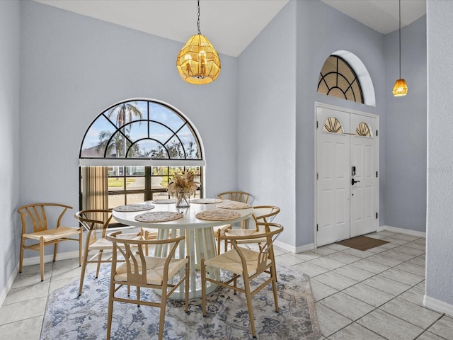 dining room with a high ceiling and light tile patterned floors