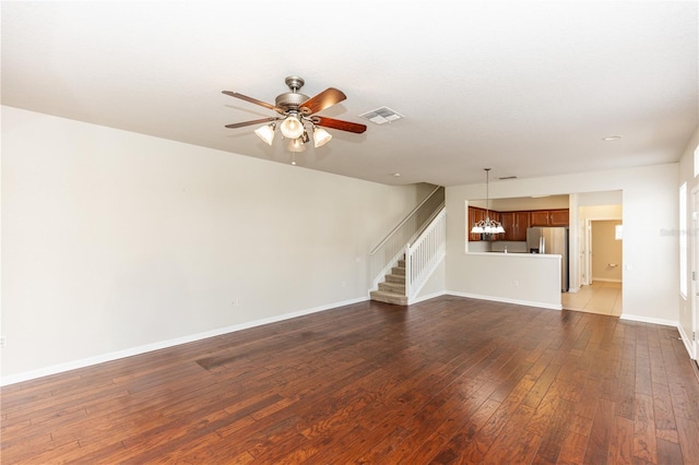 unfurnished living room featuring dark hardwood / wood-style flooring and ceiling fan